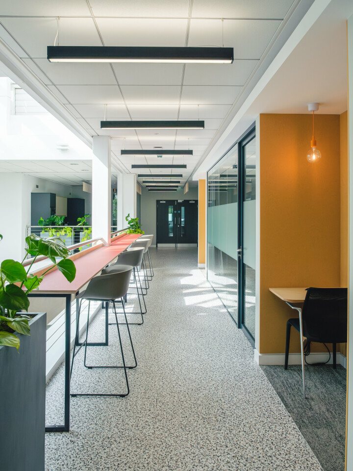 Shared desks and quiet booths along a Spaceworks corridor